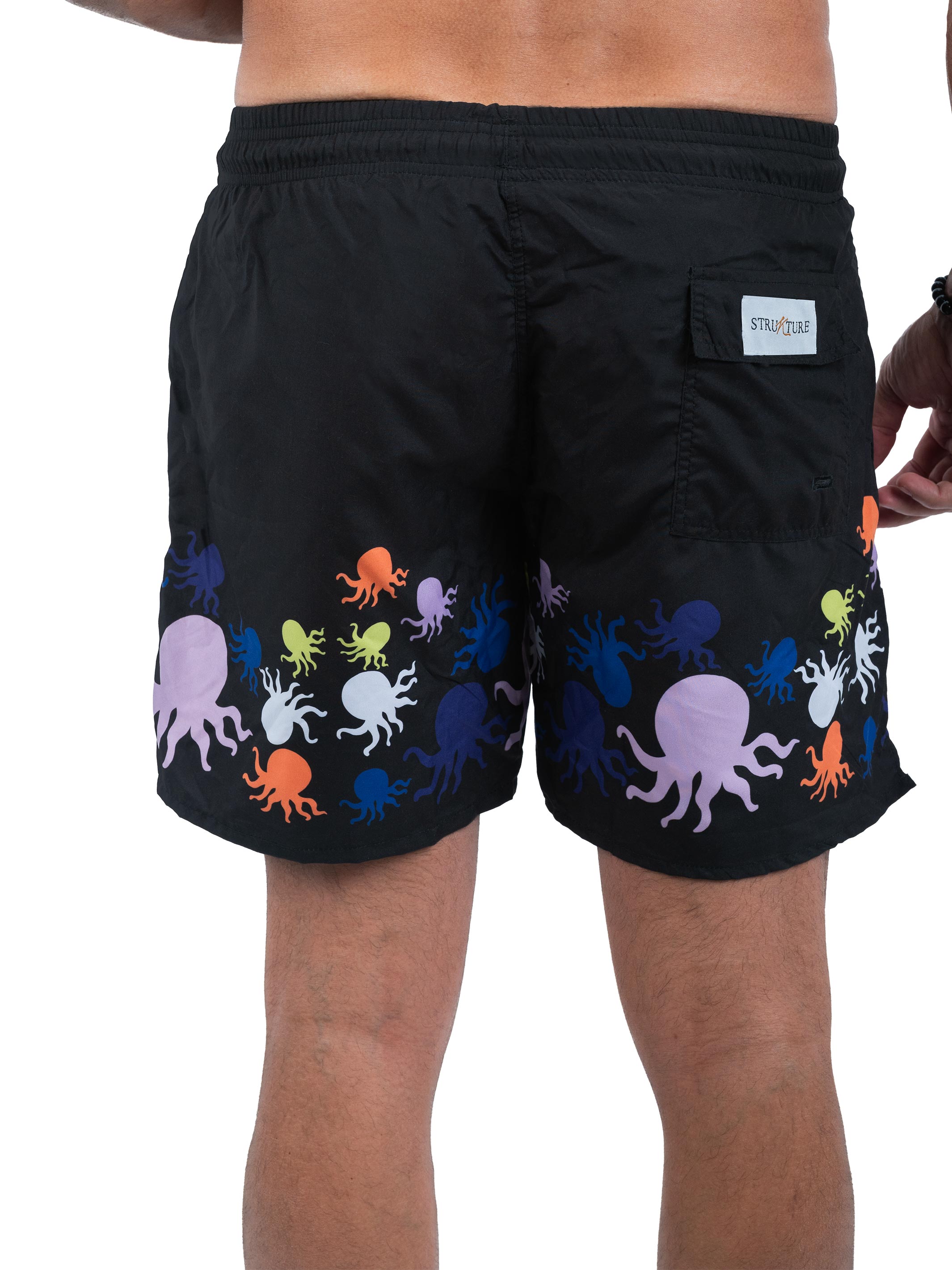 Black swim shorts with colorful octopus pattern on a white background